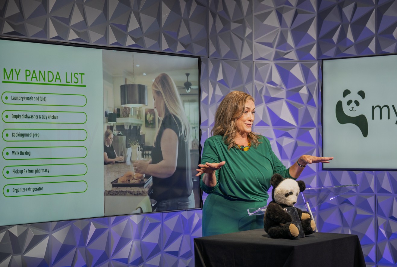 Tamara V. Lucas presenting on stage with My Panda slides on screen